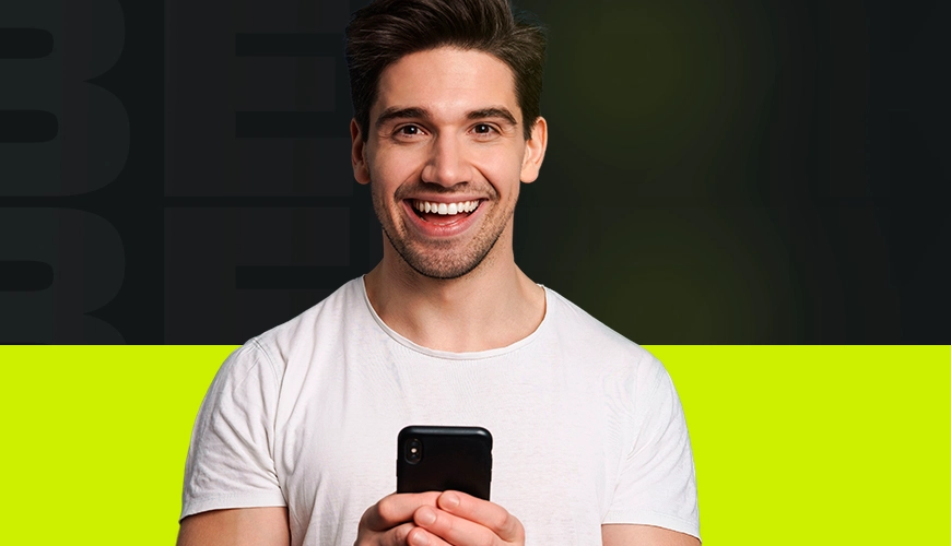 Imagem mostra homem sorrindo ao utilizar um smartphone