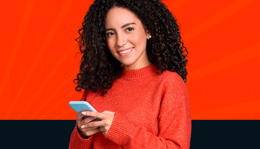 Imagem mostra mulher sorrindo ao utilizar um smartphone