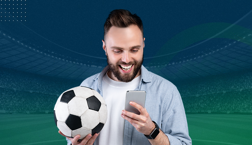 Imagem mostra torcedor sorrindo e segurando bola e smartphone