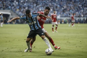 Jogadores de Grêmio e Inter disputam a bola durante GreNal