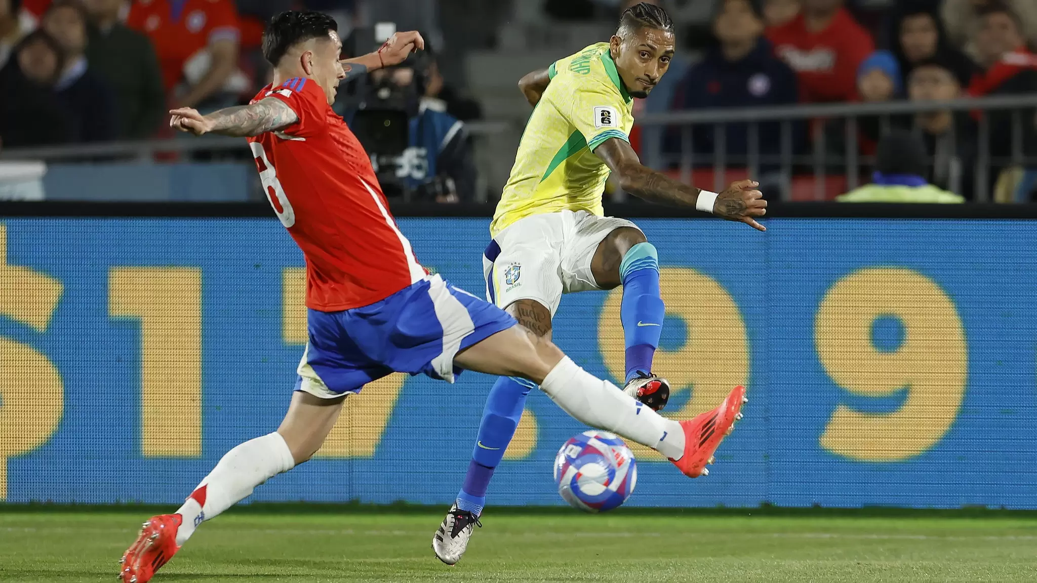 Raphinha, da Seleção Brasileira, disputa a bola com jogador do Chile, em Chile 1 x 2 Brasil, pela 9ª rodada das Eliminatórias Sul-americanas. Foto