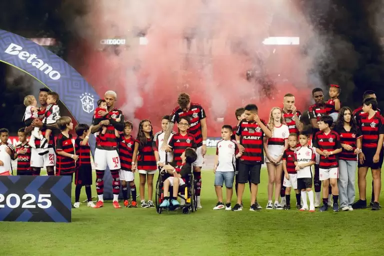 Crianças no campo com jogadores do Flamengo