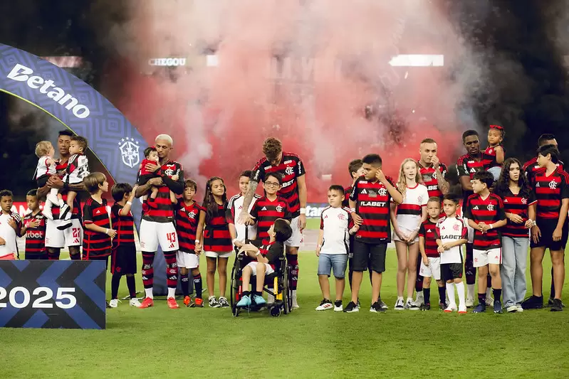 Crianças no campo com jogadores do Flamengo