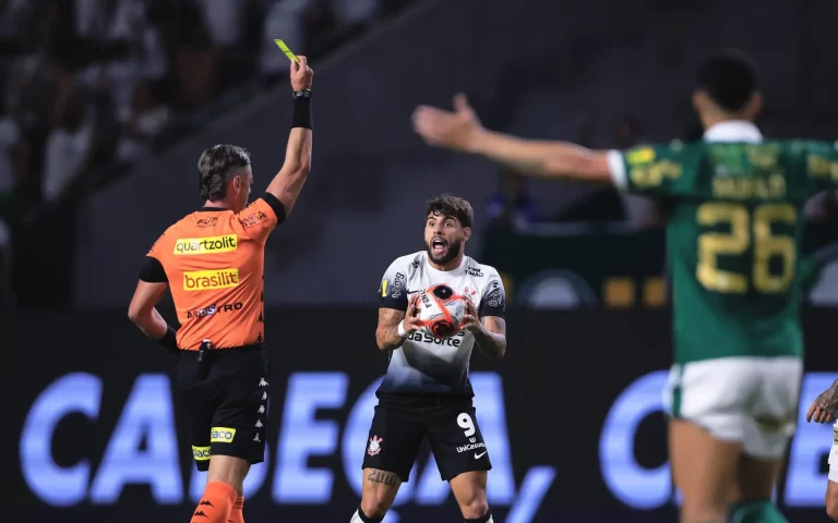 Árbitro Raphael Claus levanta o cartão amarelo para jogador do Corinthians