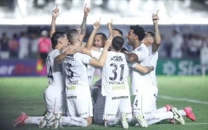 Jogadores do Santos estão ajoelhados no gramado, com Neymar ao centro