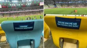 Imagem mostra cadeiras com adesivos no Maracanã, dizendo Favor torcer sentado