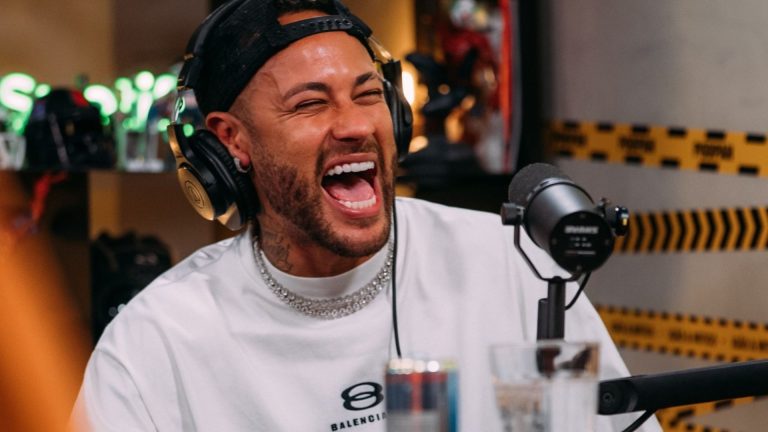 Neymar aparece no centro da imagem, sorrindo, enquanto participa de um podcast