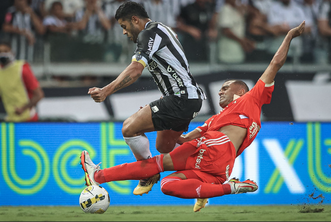 Disputa de bola entre Mercado, zagueiro do Internacional, e Hulk, atacante do Atlético-MG