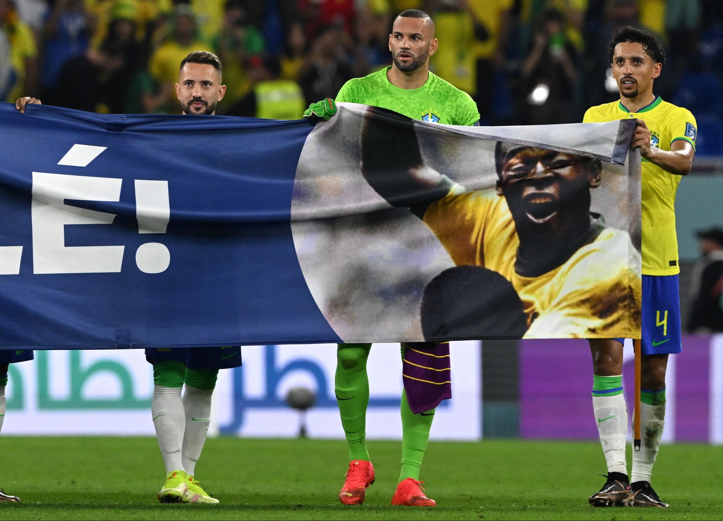Brazil's forward #21 Rodrygo, Brazil's midfielder #22 Everton Ribeiro, Brazil's goalkeeper #12 Weverton and Brazil's defender #04 Marquinhos hold a banner depicting Brazilian football superstar Pele as he celebrates after qualifying to the next round after defeating South Korea 4-1 in the Qatar 2022 World Cup round of 16 football match between Brazil and South Korea at Stadium 974 in Doha on December 5, 2022. (Photo by Pablo PORCIUNCULA / AFP) (Photo by PABLO PORCIUNCULA/AFP via Getty Images)